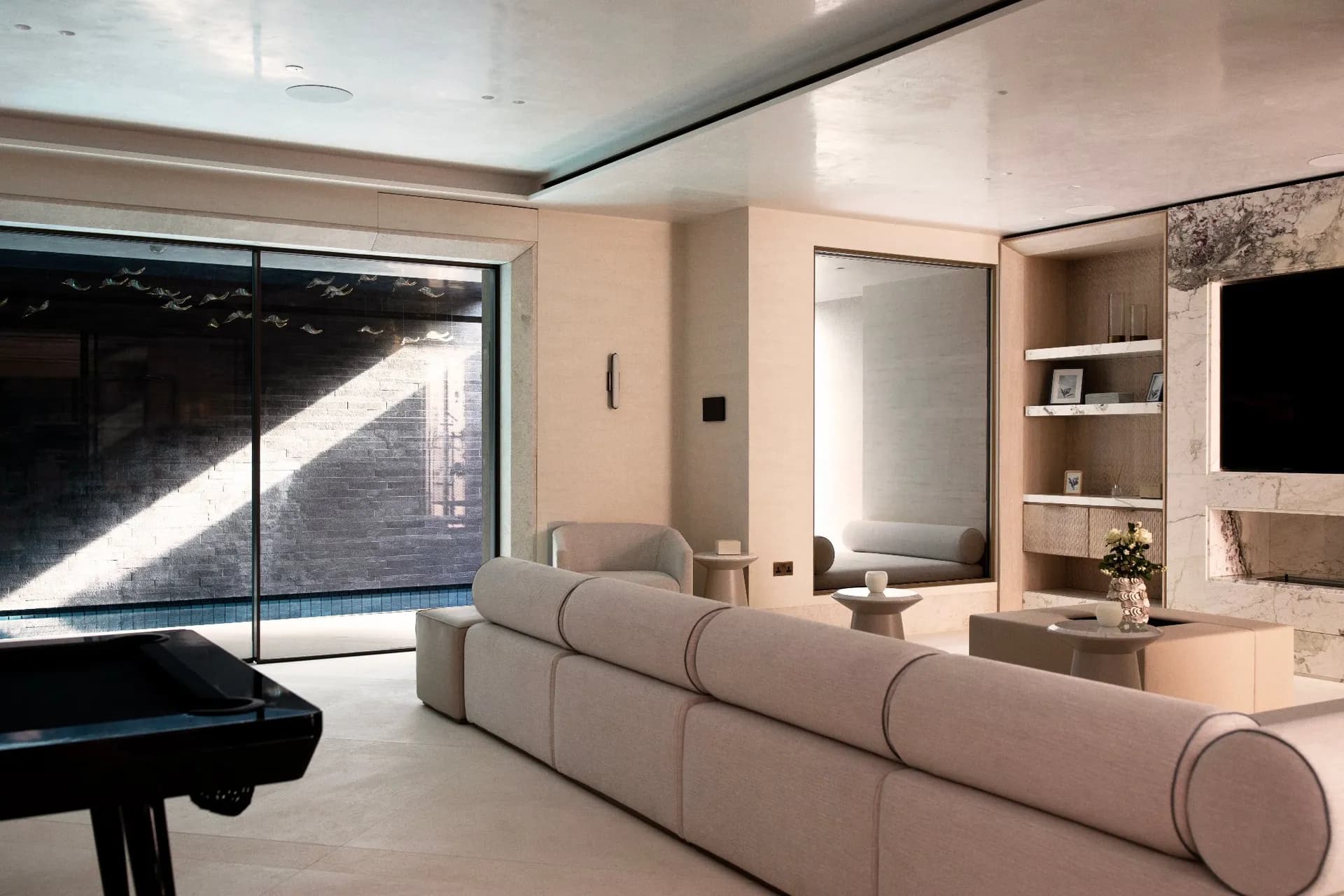 Basement leisure room with games area, marble media wall and glazed link to an indoor pool
