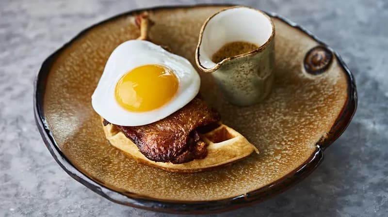 The house signature, duck leg, waffle and a fried duck egg, with mustard maple syrup.